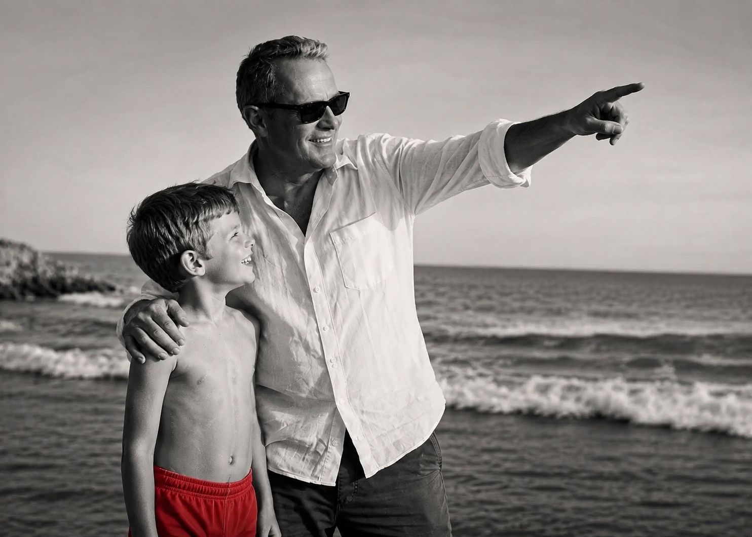 Mark Elliot beside a young boy in red swimming trunks, looking towards the future